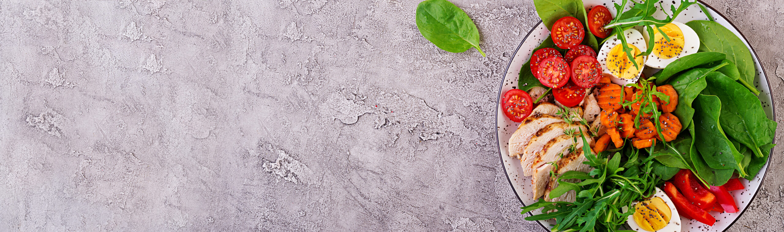 Image plate with keto diet food cherry tomatoes chicken breast eggs carrot salad with arugula spinach keto lunch top view