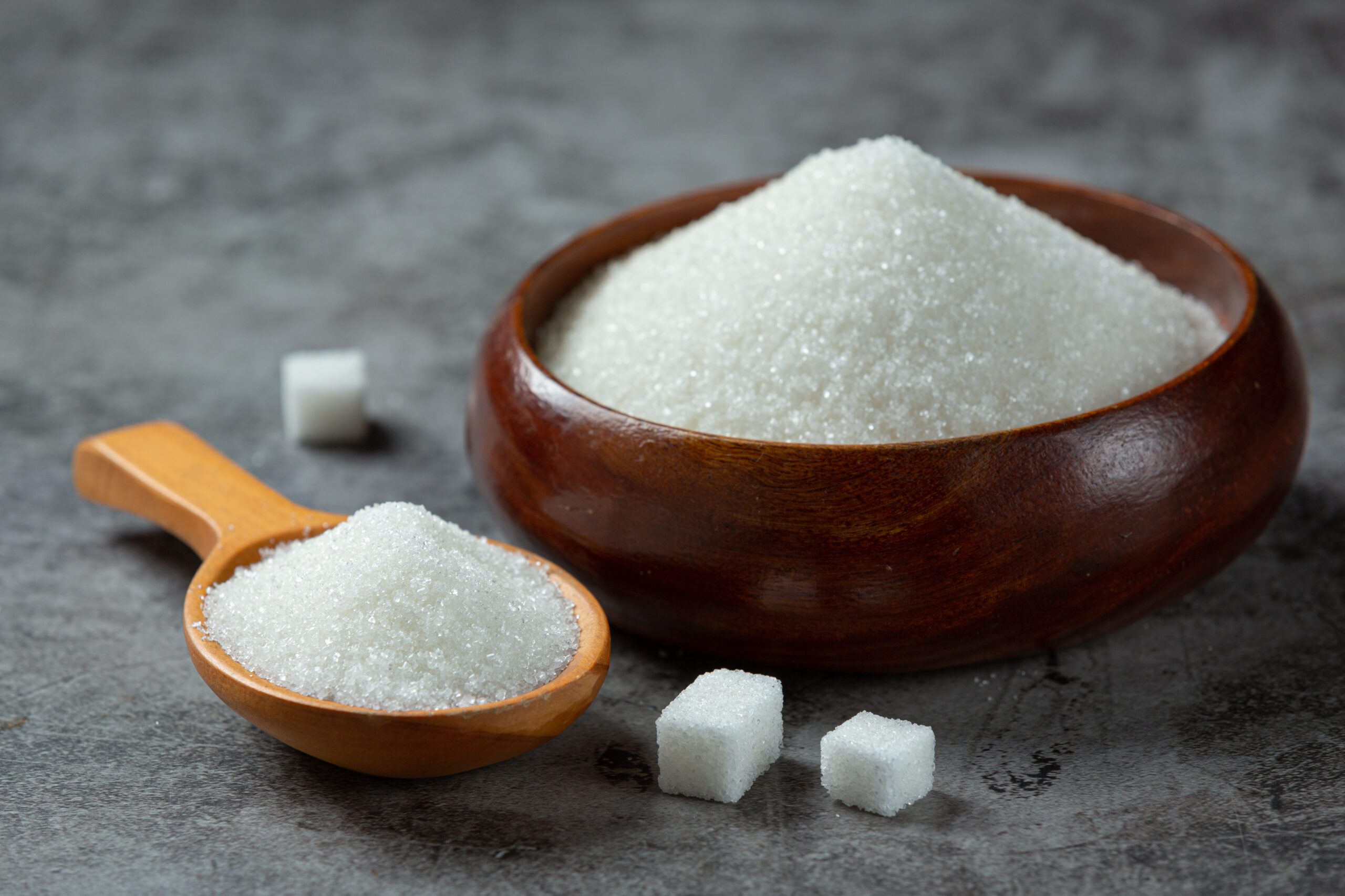 Image World diabetes day; sugar in wooden bowl on dark background